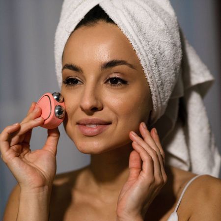 Black friday skincare tools - woman using microcurrent device