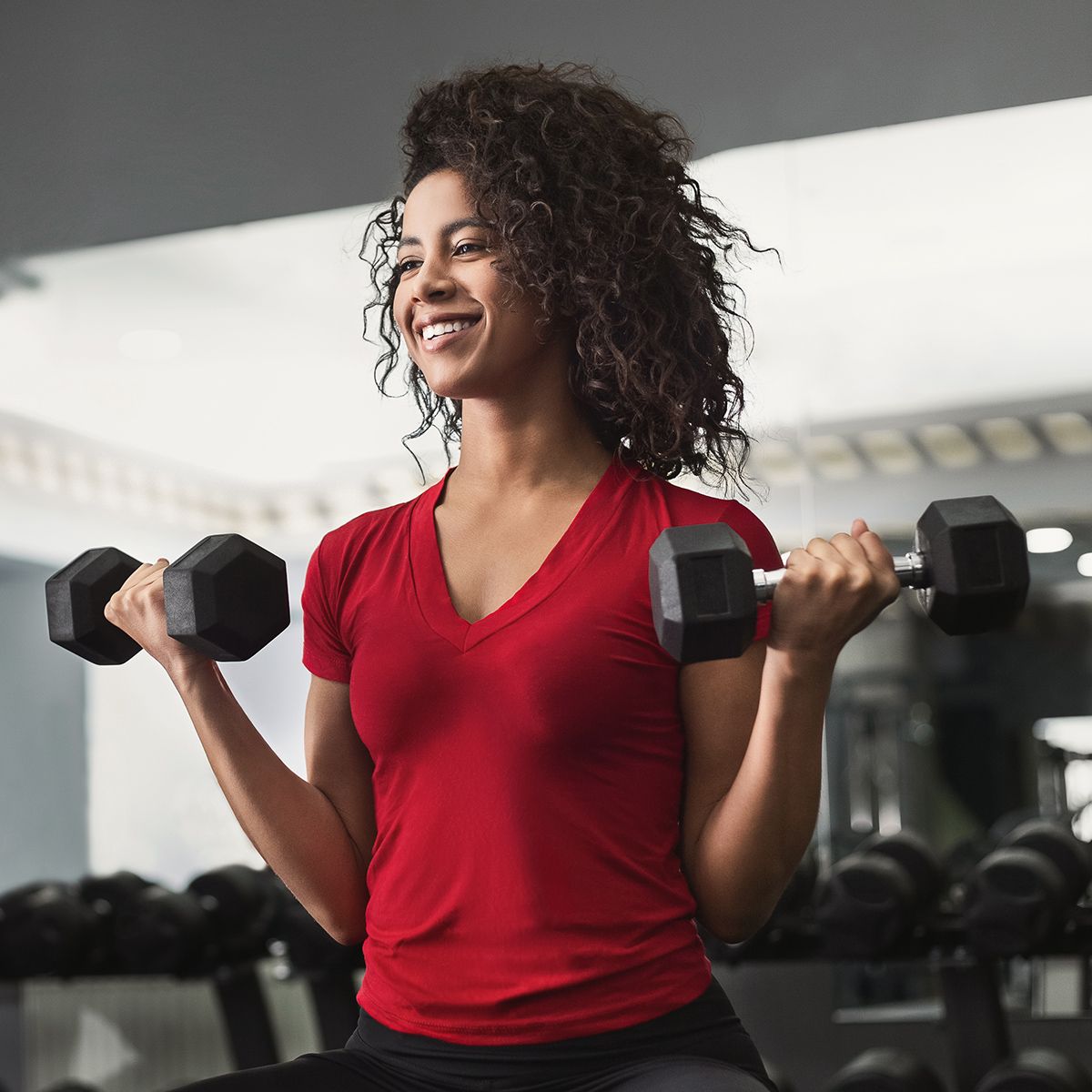 Fit young woman working out with dumbbells