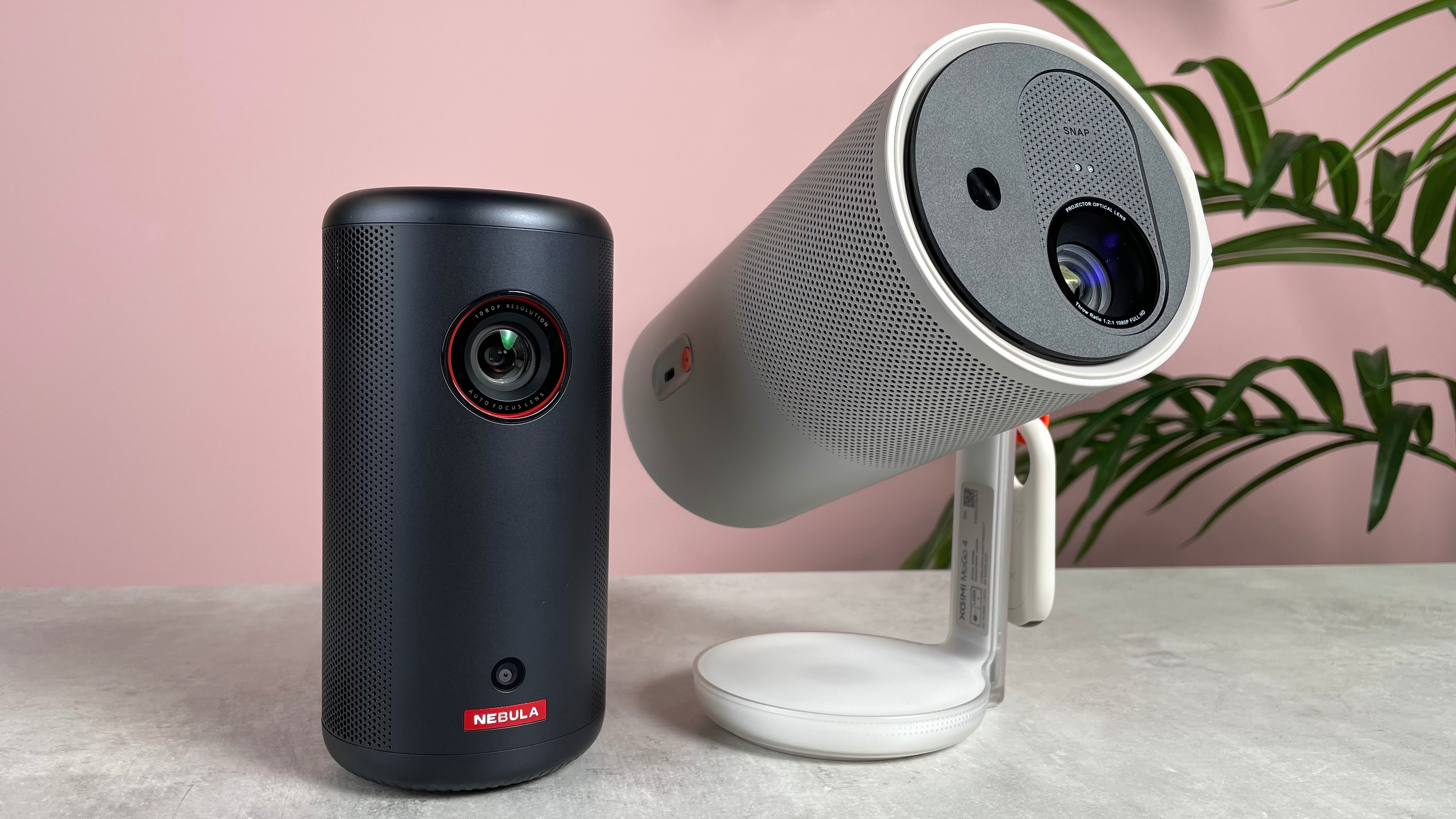 The flat-sitting Anker Nebula Capsule 3 is pictured next to the XGIMI Mogo 4, which is angled up to the right.