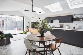a Rebecca Graham kitchen with dark blue fixtures, white walls and a monochrome floor