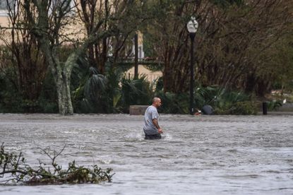 A man walks down a flooded street in Pensacola, Florida.