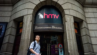 A man walks past a building housing a HMV store in Hong Kong on January 17, 2013. Iconic British music retailer HMV is fighting for survival after slumping into administration, but its boss e