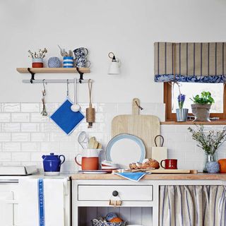 kitchen with white tiles on wall and crockery