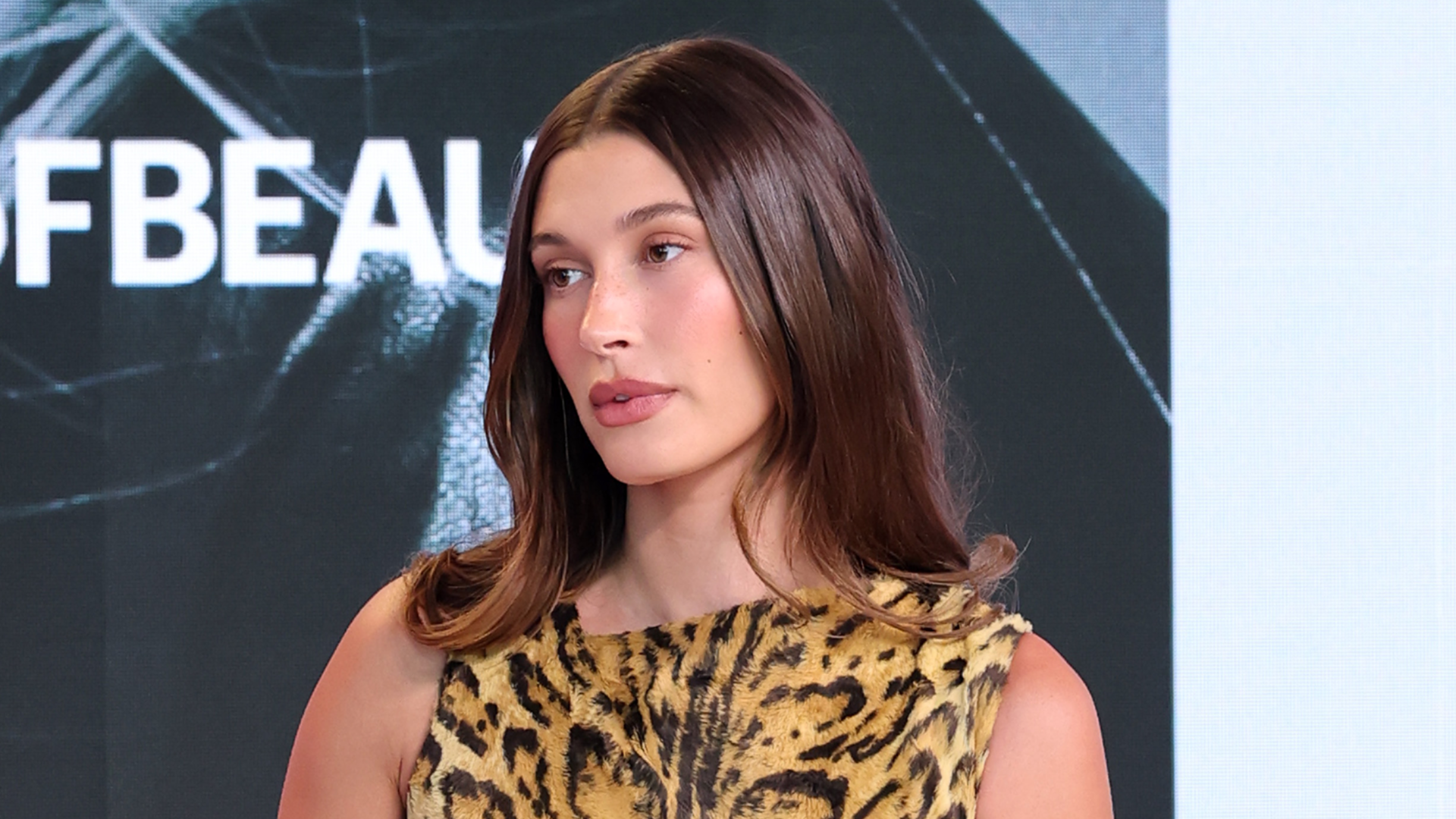 Hailey Bieber attends the Business of Beauty Global Forum in a vintage Versace leopard print dress.