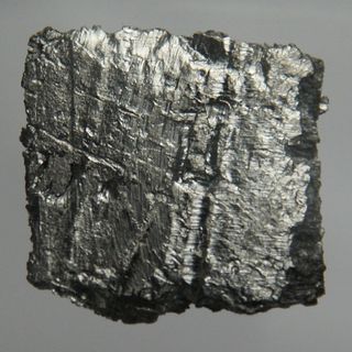 Ultrapure erbium with cut traces, 25 grams. This piece is 1 by 2 by 2 centimeters.