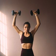 A woman doing the best shoulder exercises for women in a gym