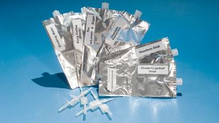 several silver foil pouches with labels and plastic straws with clamps