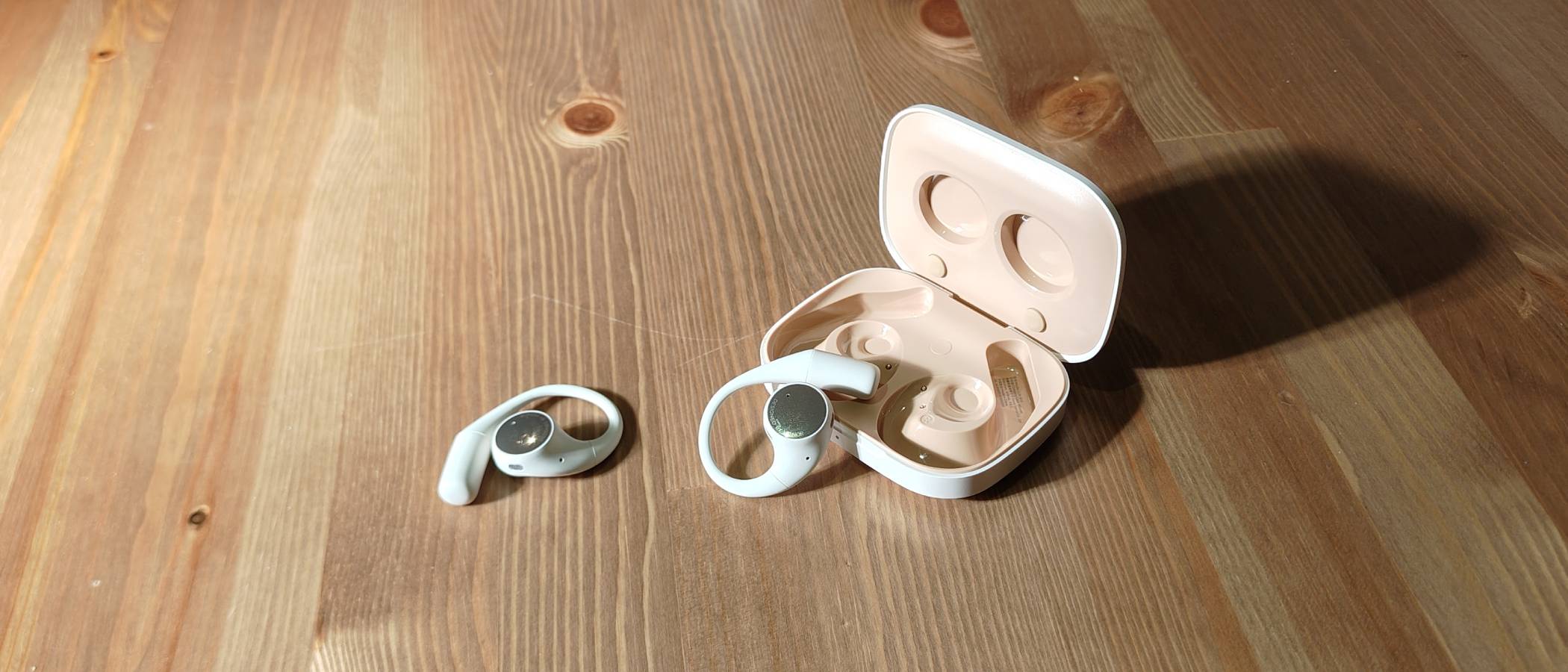 The Honor Earbuds Open on a brown table.