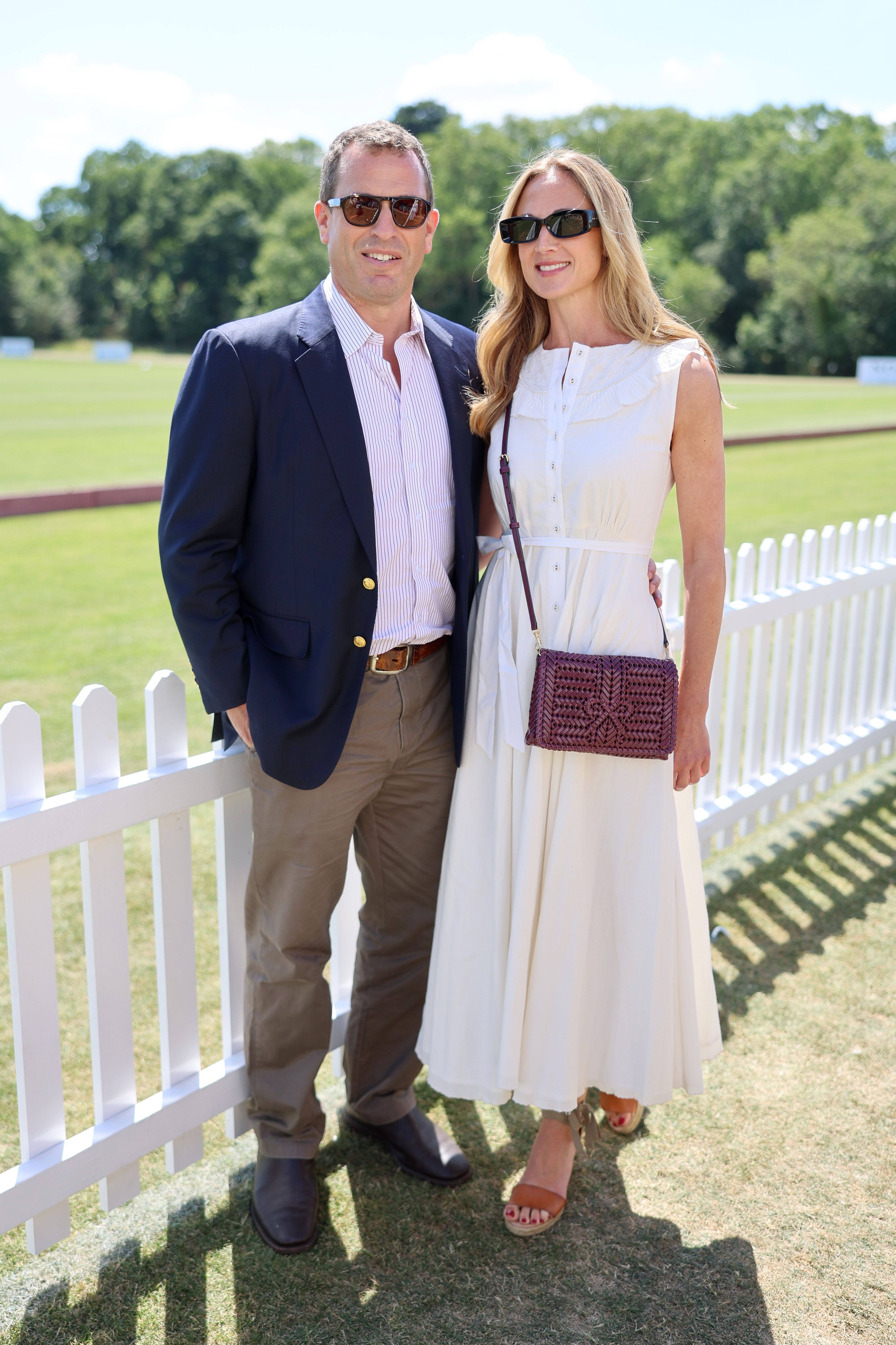 Harriet Sperling and Peter Phillips posing in front of a fence at Guards Polo Club