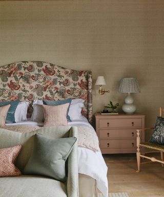 Bedroom with upholstered headboard, tble lamp, wall lamp, and sofa