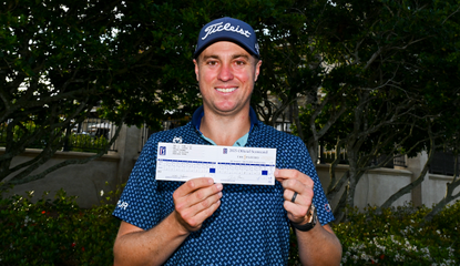 Justin Thomas holds his scorecard at TPC Sawgrass