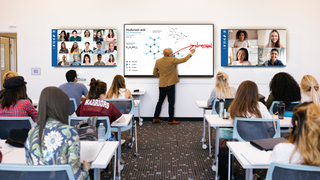 A teacher stands at a white board teaching with LG Business Solutions technology.