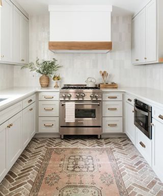 White kitchen, brick floor, rug