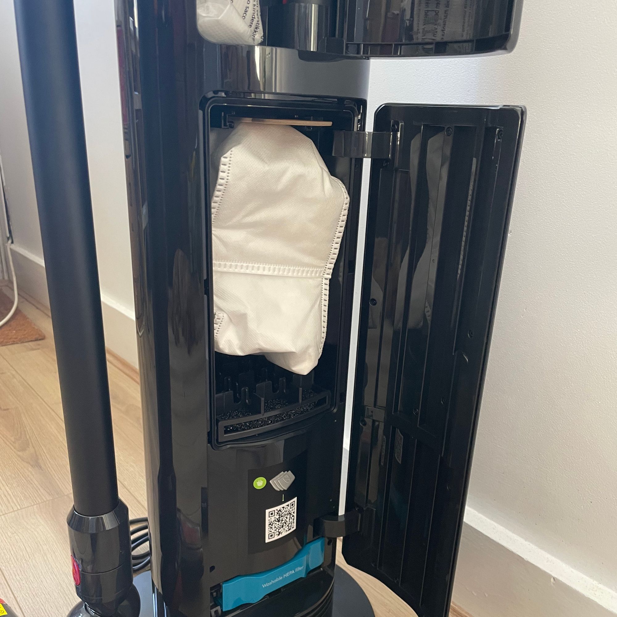 The dust bag of the Dyson V10 Konical sitting inside of the black auto-empty dock
