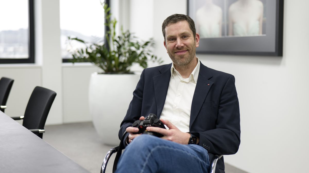 Leica SL System product manager, Steffen Rau, sat at a desk holding a Leica SL3