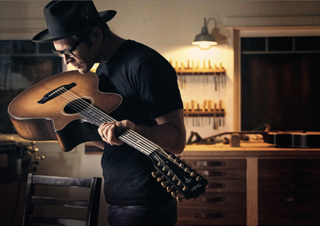 Andy Powers holds a Taylor guitar