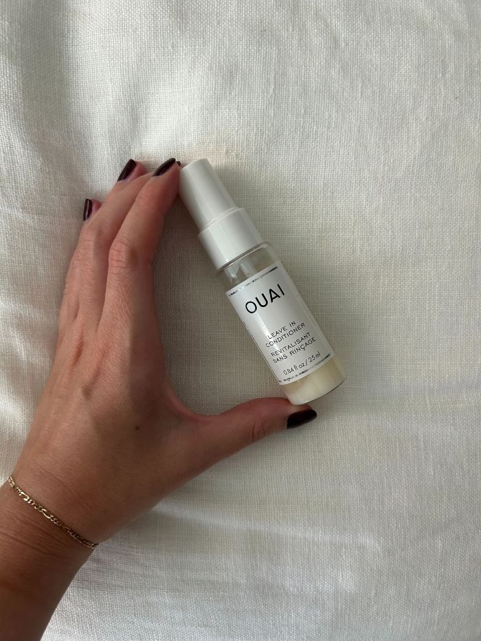 junior beauty editor grace lindsay holding a ouai leave-in conditioner