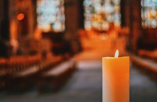 A close up of a candle inside a church.