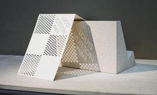 White laser cut out pattern on an invite card