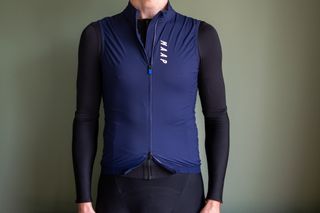 A man wearing a blue MAAP Draft gilet with black jersey and arm warmers