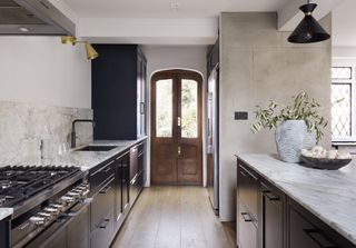 dark wood long and narrow kitchen with white worktop