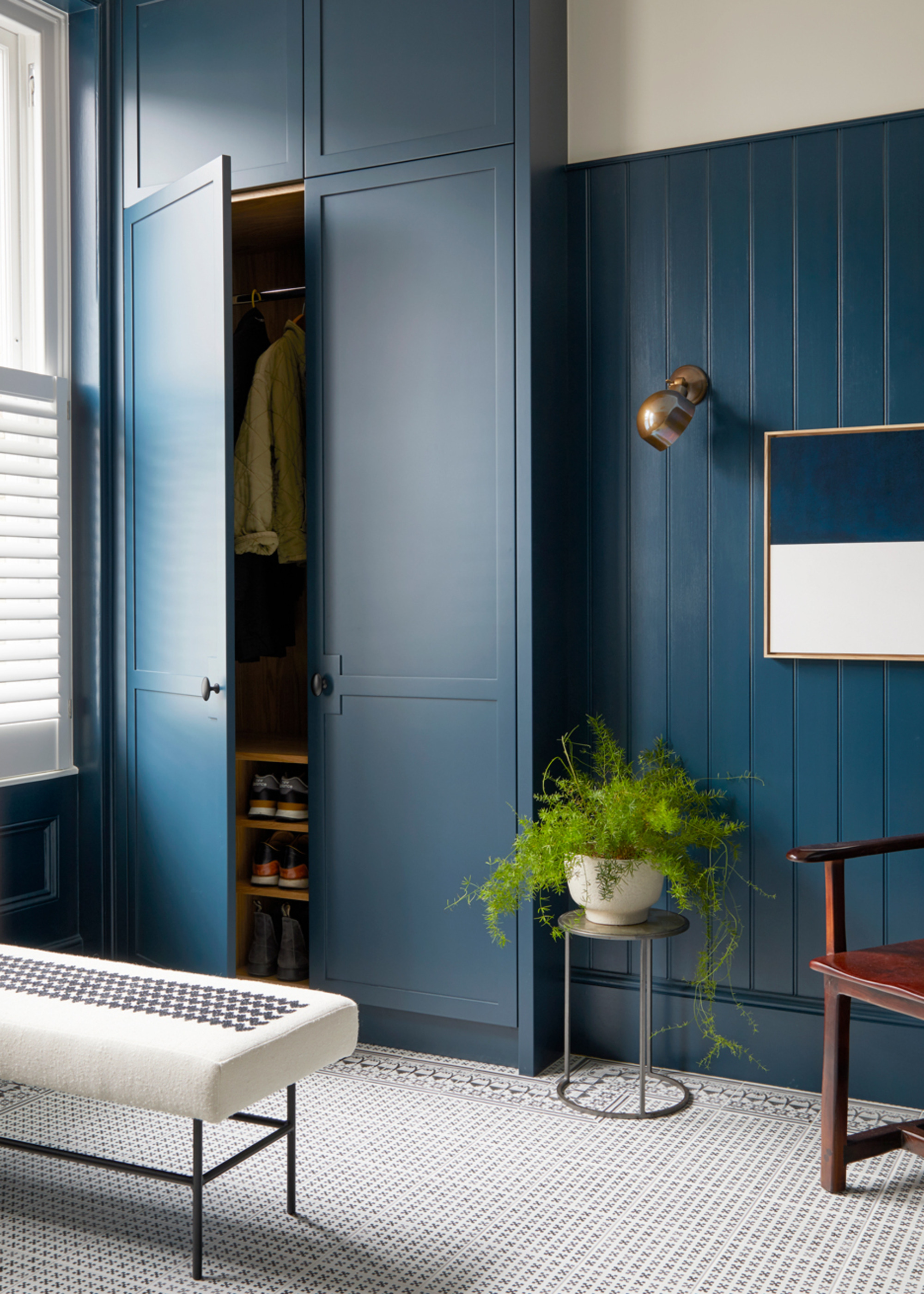 A boot room with bespoke storage painted deep blue