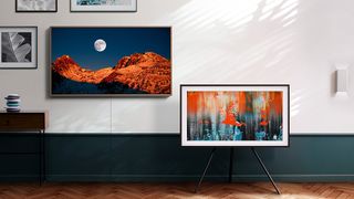 samsung the frame tv 2020 pictured on a stand next to a wall of works of art