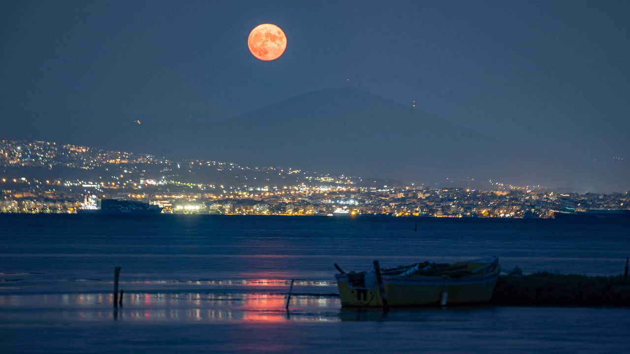 The August Sturgeon full moon rises behind the Hortiatis mountain and Thessaloniki, Greece, on Aug. 22, 2021.