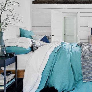 bedroom with white walls and aqua blue bedding set