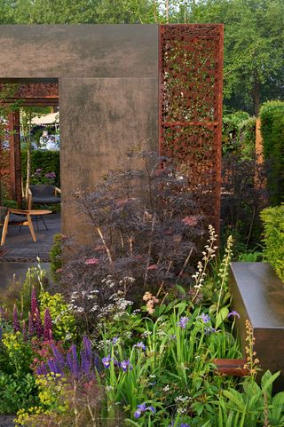 urban narrow garden with metal screen and flowers