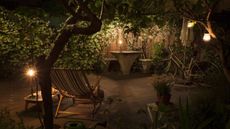 A candle-lit backyard with seating and flowering star jasmine
