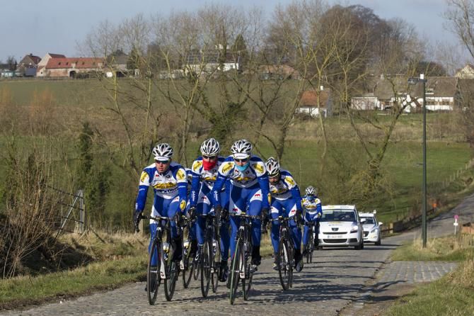 Topsport Vlaanderen-Baloise riders recon a cobbled sector of the Omloop Het Nieuwsblad route.