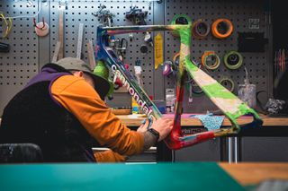 Man preparing a handpainted Cannondale SuperSix EVO frameset to be used in the 2023 Giro by the EF Education pro cycling team