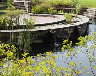two tier backyard pond in USA with water lilies and pond plants