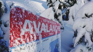 Avalanche warning sign on snowy mountain