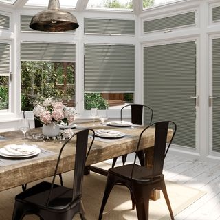 Conservatory with grey-wash wooden floor and grey blinds