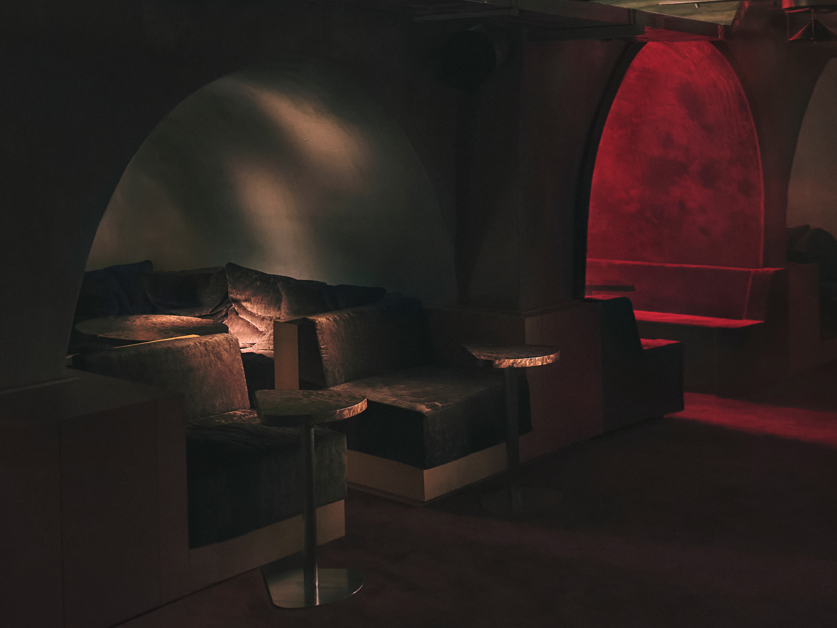 view of an underground bar in london defined by low lighting and velvet textures
