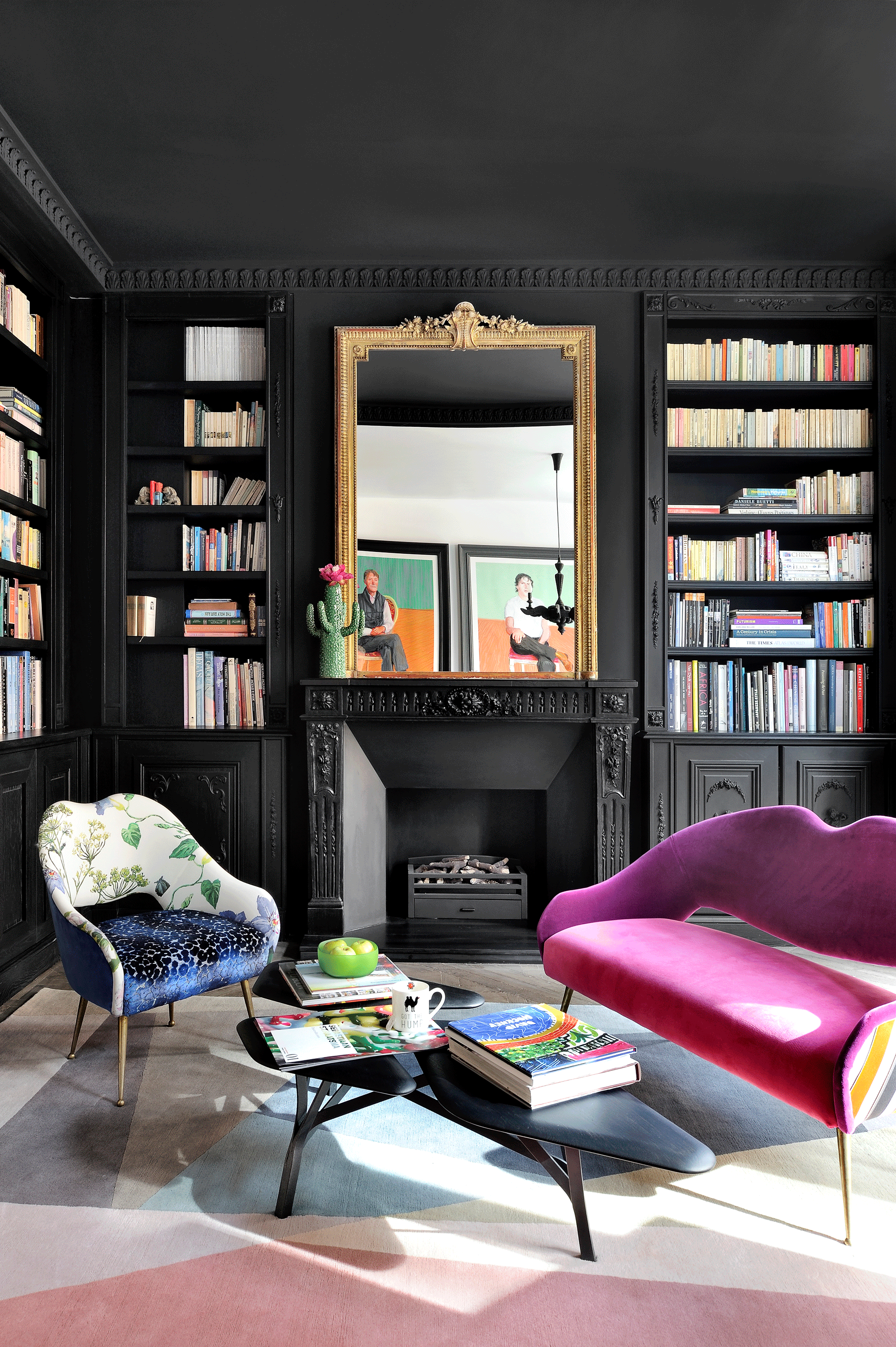 Dark living room painted all over in black with pink armchairs