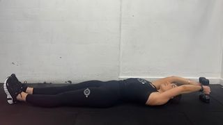 Personal trainer at FS8 Oxford Circus Emily Rutherwood performing a dumbbell jackknife