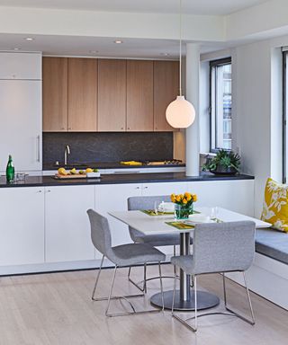 black and white kitchen, black countertops, white cabinetry, modern, kitchen dining space, yellow accents