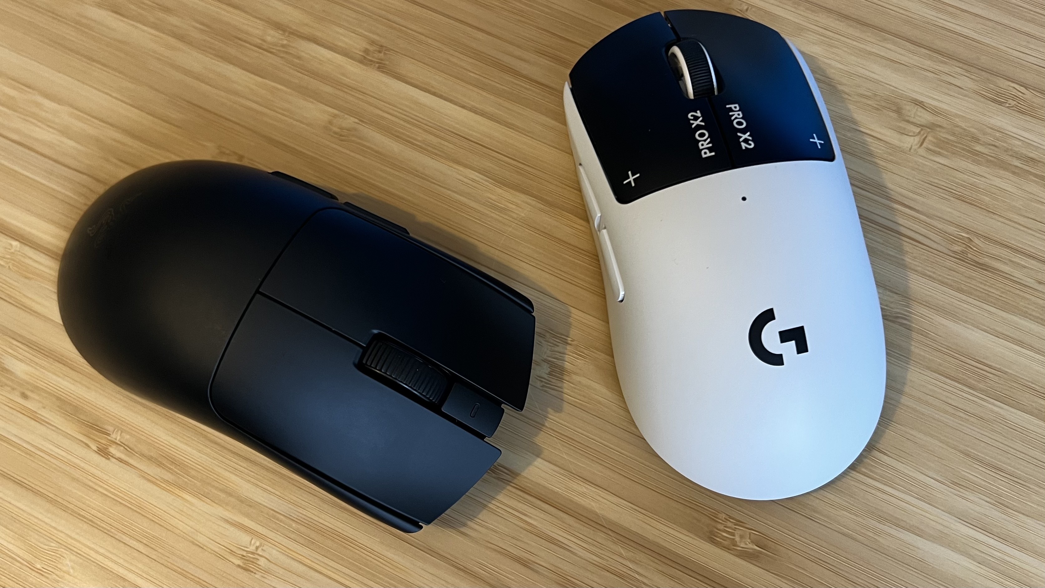 Razer Viper V4 Pro and Logitech G Pro X 2 Superstrike gaming mice on a wooden desk