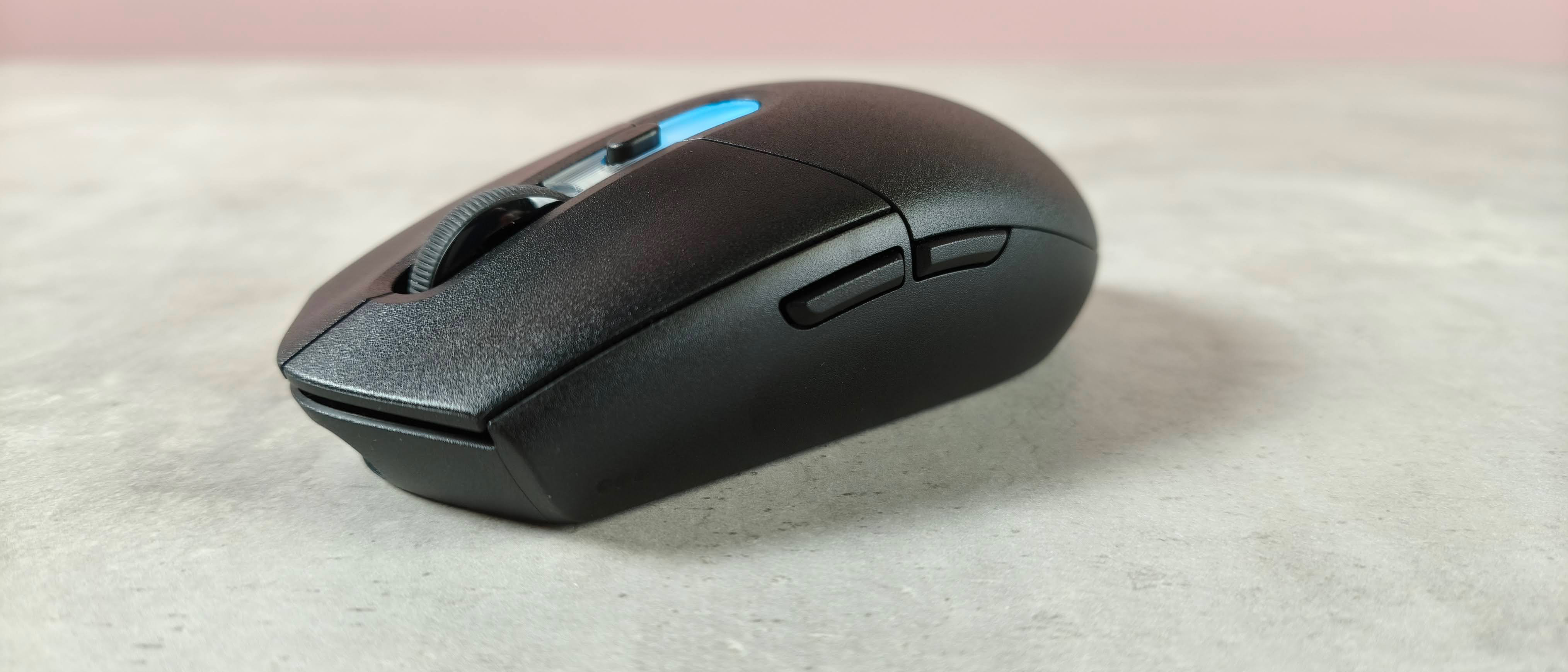 Three-quarter view of Logitech G305 X Superlight on desk with pink wall in background