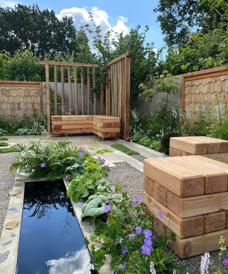 modern garden with pond, wooden stools and timber pergola