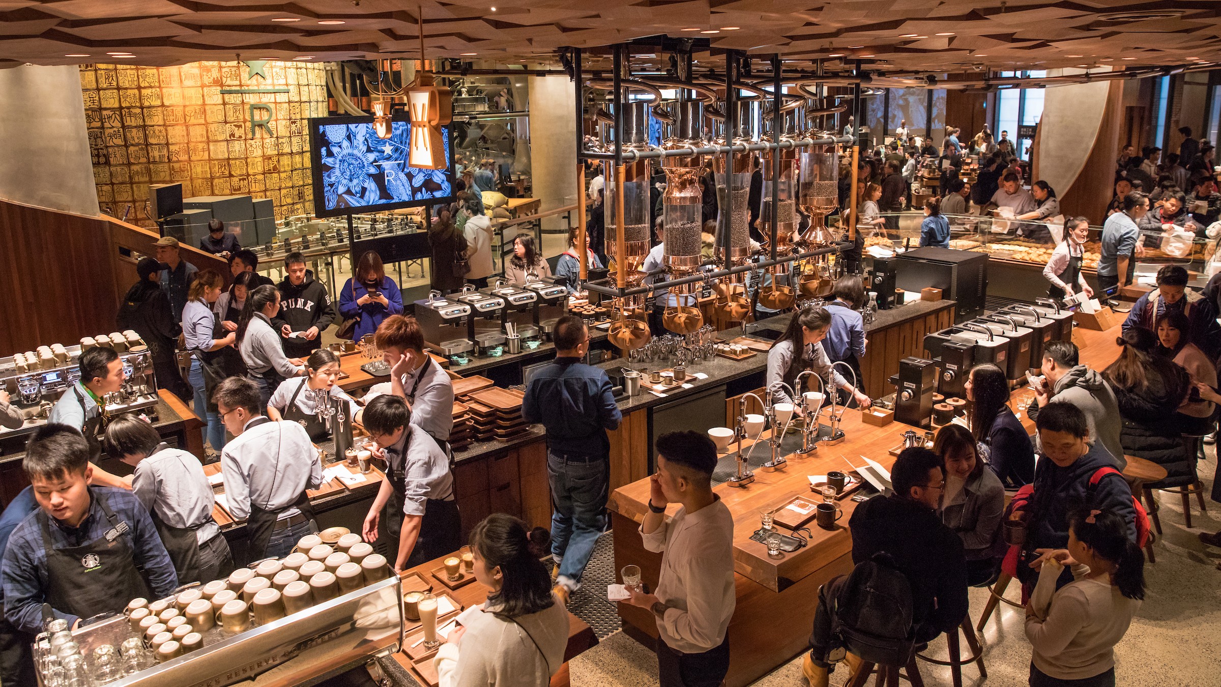 People drinking coffee and socialising in Starbucks cafe