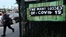 A person walks by tributes in art made by 20 community groups to those impacted by Covid-19, done in collaboration between Naming the Lost Memorials, City Lore and Green-Wood Cemetery, at Green-Wood Cemetery on May 08, 2023 in the Brooklyn borough of New York City