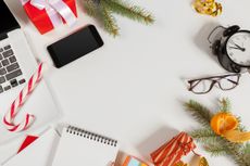 various office supplies mingled with holiday items like pine, presents, and a candy cane