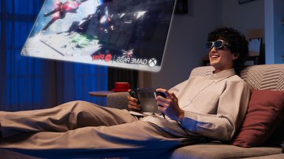 A person gaming using the Lenovo Legion Glasses, with a render of the approximate screen size