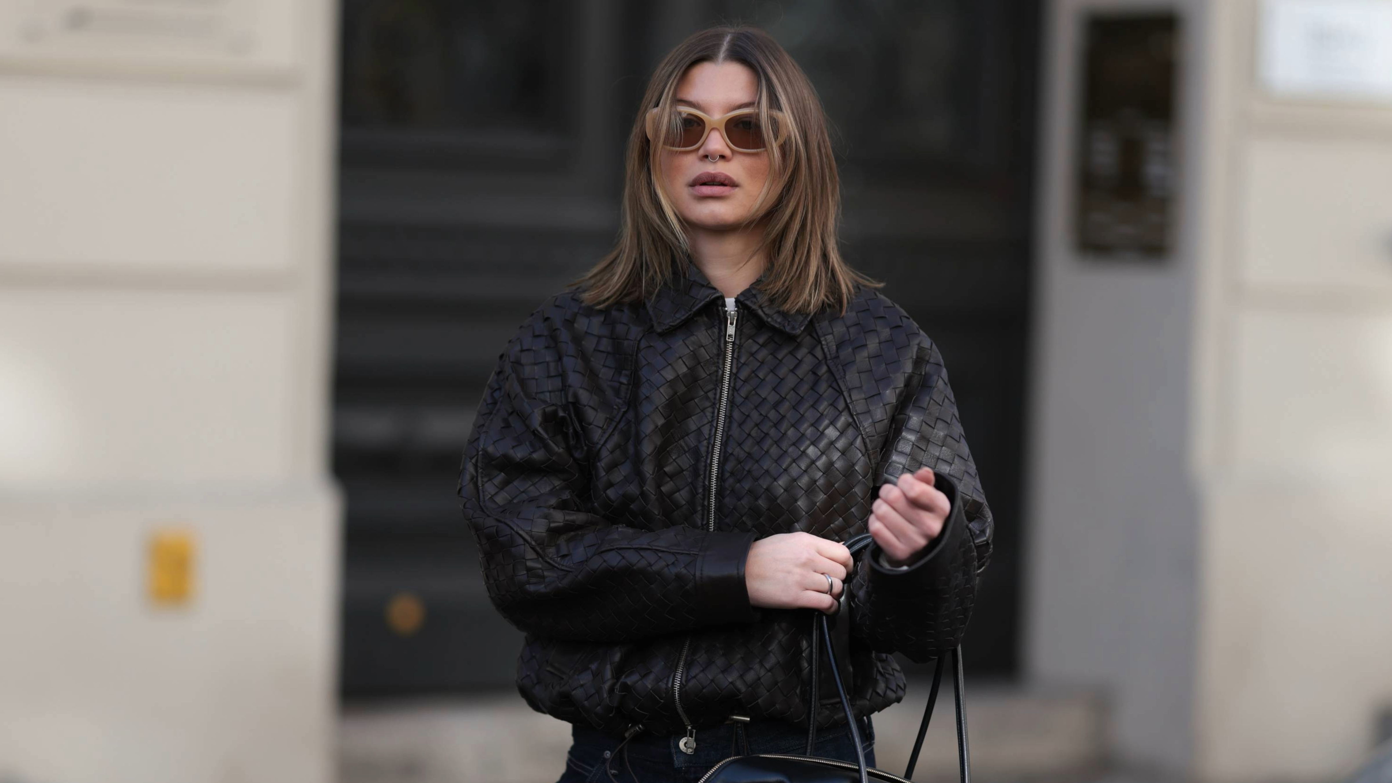 BERLIN, GERMANY - APRIL 01: Sophia Geiss seen wearing a woven-texture Second Female jacket paired with dark Uniqlo wide-leg jeans with turned-up hems, styled with a structured DeMellier bag, and P.J. Lobster sunglasses, with mid-length hair worn loose in soft, natural waves and a subtle center part on April 01, 2026 in Berlin, Germany. (Photo by Jeremy Moeller/Getty Images)