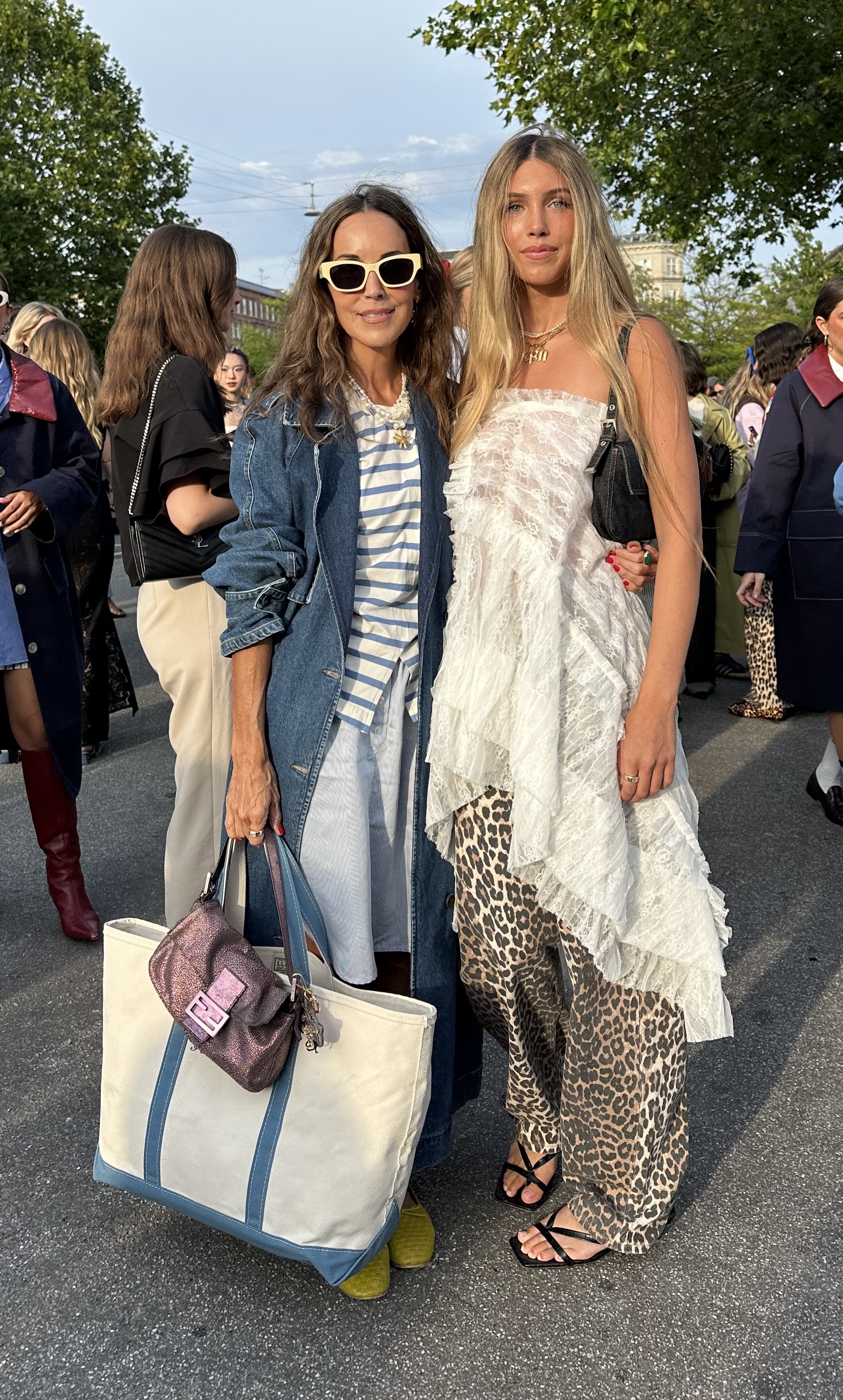 Larissa Mills wearing a white and blue striped shirt, jean jacket, striped skirt, and canvas L.L. Bean boat and tote bag with her daughter Ella Potter Mills