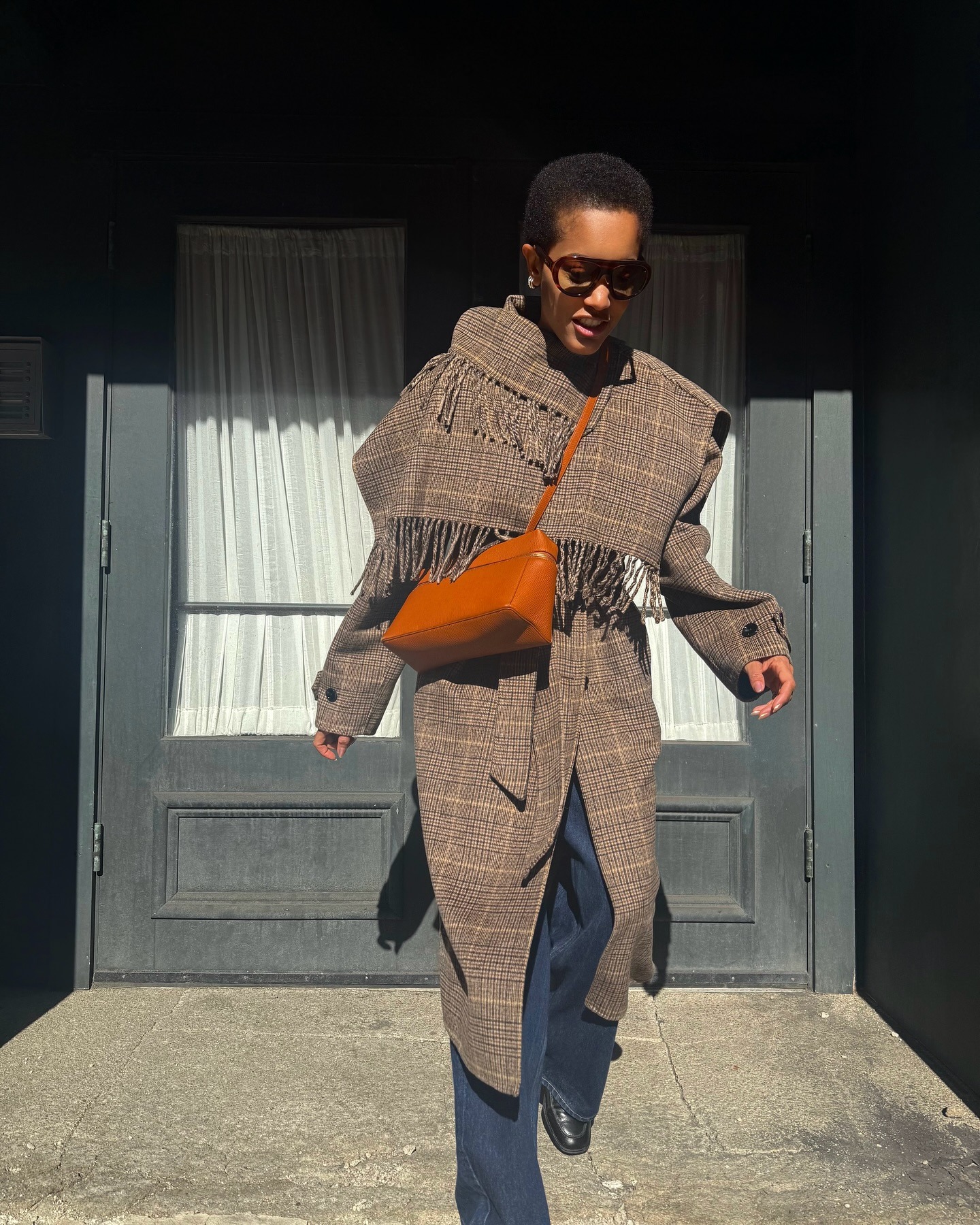 Tamu McPherson wears a plaid fringe coat